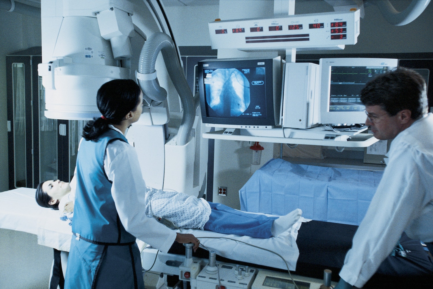 sideview of two doctors giving a patient an MRI scan